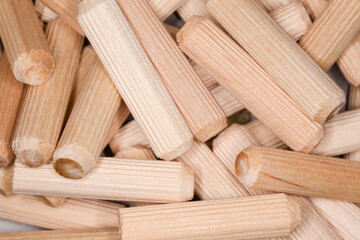 Pile of wooden dowel pins close-up, background