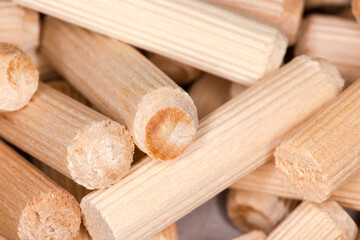 Pile of wooden dowel pins, close-up in selective focus