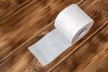 A roll of toilet paper on a wooden table. Close up.