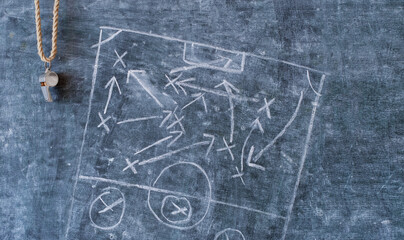 whistle of a soccer or football referee on black board with tactical diagram, free copy space
