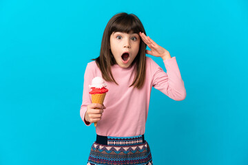 Little girl with a cornet ice cream isolated on blue background with surprise expression
