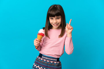 Little girl with a cornet ice cream isolated on blue background showing and lifting a finger in sign of the best