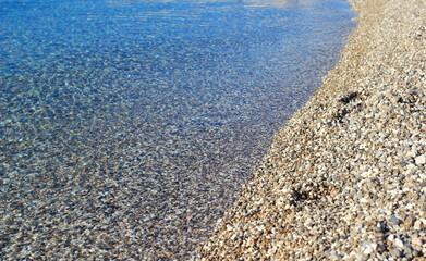 Clear transparent sea with rocky pebbles bottom on the beach in town Senj, Adriatic sea, Croatia