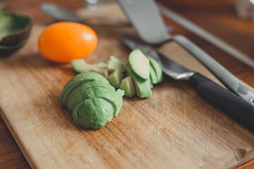 Pieces of avocado and tomato vegetables on a cutting wooden board