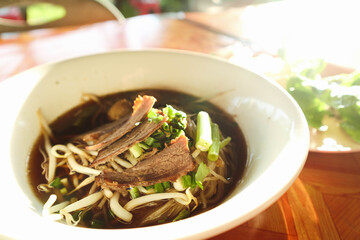 Close-up beef noodles with fish ball and vegetable in dish.