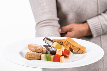 plate with an assortment of nougat and other traditional sweets being held by an out of focus person