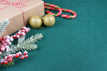 Christmas background with decorations and gift box on green felt background.