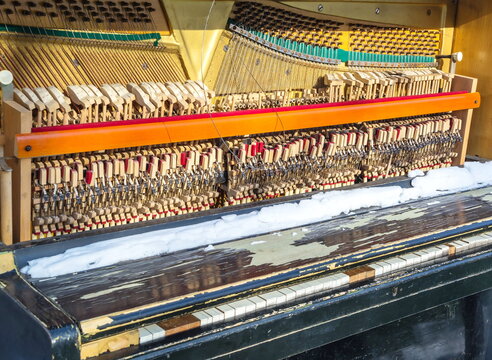 Abandoned piano with torn strings and broken keys