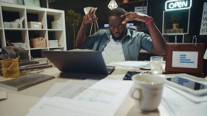Portrait of rested male professional having fun near laptop at workplace.