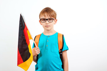 Cute school boy with backpack holding german flag. People, education, learning and school concept.