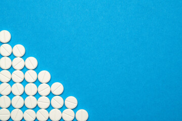 group of round white pills on blue background