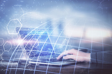 Multi exposure of world map hologram with man working on computer on background. Concept of worldwideweb.