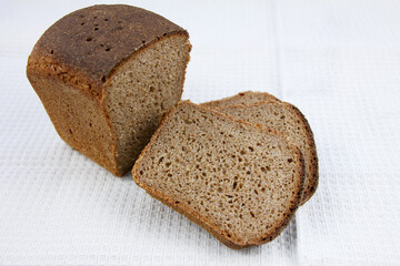 Homemade rye sourdough bread with a crisp crust on moneycomb towel backgroun.