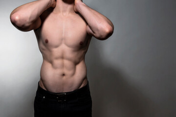 Fototapeta na wymiar Muscular and fit bodybuilder shirtless on grey background