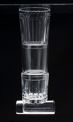 Vertical image.Stack of empty glasses against dark background