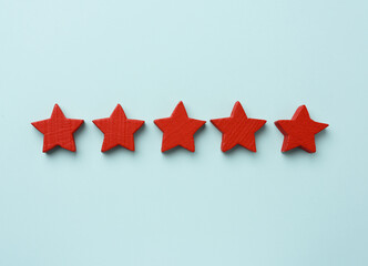 five red wooden stars on a blue background, high score