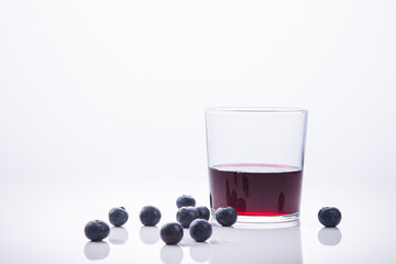 Blueberry juice glass with blueberries on  white background.