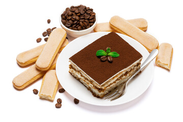 Traditional Italian Tiramisu square dessert portion on ceramic plate, savoiardi cookies and coffee beans isolated on white
