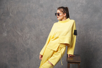 Young woman in yellow sportswear, pants and sweatshirt. Concept of fashionable sport outfit,...