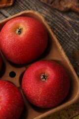 Juicy red apples and autumn leaves on the table