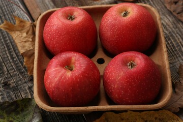 Juicy red apples and autumn leaves on the table