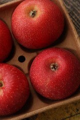 Juicy red apples and autumn leaves on the table