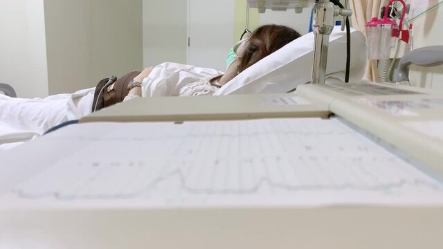 Pregnant asian woman with electrocardiograph check up for her baby. Fetal heart monitoring. Diagnostic, healthcare, medical service 