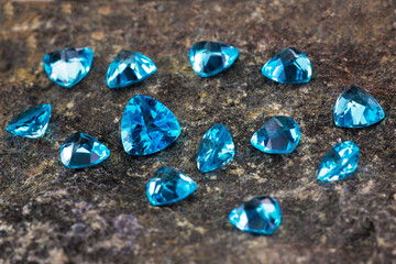 a scattering of beautiful blue topaz on a natural wild stone