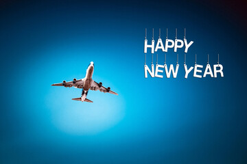 The plane flies on a blue background with the inscription Happy new year.