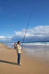 photograph of a fisherman on the beach