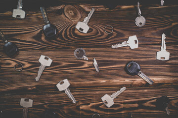A studio photo of a broken key among many normal keys on a wooden background.
