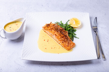 Salmon with beurre blanc sauce, spinach and lemon. Garnished with leeks. Traditional French dish....