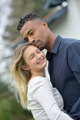 Portrait of young loving couple embracing each other, mixed ethnicity