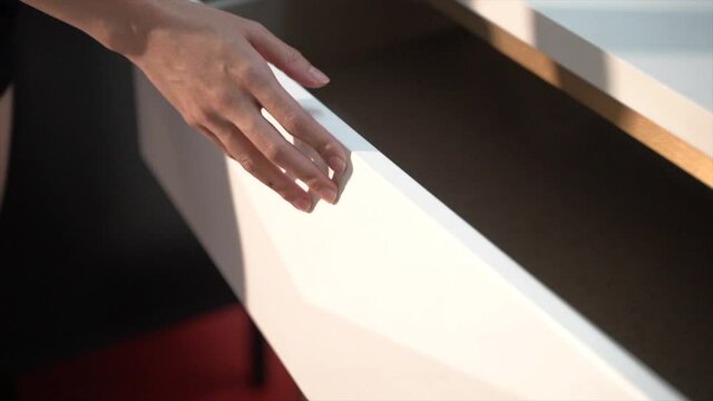 Hand open and close white slide wooden drawer.
