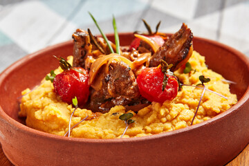 Hummus with beef served in brown bowl