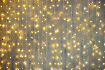 Christmas background - festive garland lights over grey wall