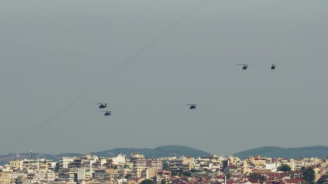 Military helicopters flying above a city. Greek Air Force AH-64 Apache, Kiowa Warrior & Huey UH-1H on formation in Thessaloniki at October 28 commemorating Hellenic no against Italian 1940 ultimatum.