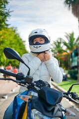 woman motorcyclist adjusting her helmet, concept of safety on the road