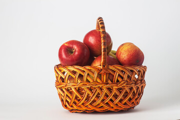 Ripe apples in a wicker basket handmade on a white background. Isolated still life