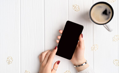 Woman with minimal pink spring summer manicure design holding smartphone