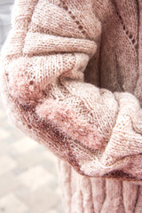 Fototapeta na wymiar Young beautiful woman in a cozy nude cardigan spends time outdoors. Close up. Without face, no face