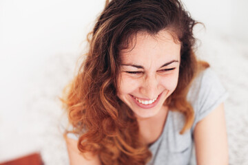 Close up portrait of a young woman laughing hard
