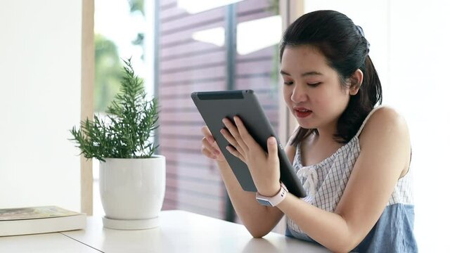Young lady is happy to play the laptop enjoying surfing internet study work shopping online using social media apps or watch her favorite series in a quiet caf&eacute;, 4K footage.