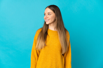 Fototapeta premium Young Lithuanian woman isolated on blue background looking side