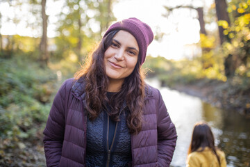 Happy woman standing next to a river in the forest