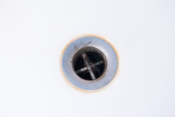 Hair clogged bathtub drain sink close up shot top view