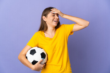 Young Lithuanian football player woman isolated on purple background smiling a lot