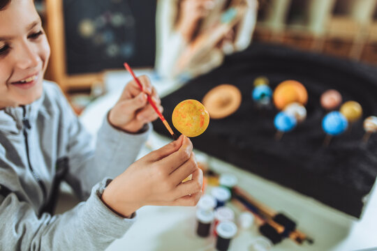 Happy School Boy And Girl  Making A Solar System For A School Science Project At Home