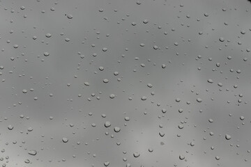 Water drops on window background on cloudy day.