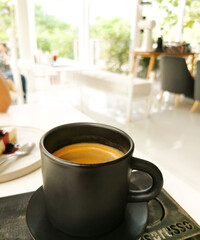 cup of black coffee on white table in coffee shop atmosphere